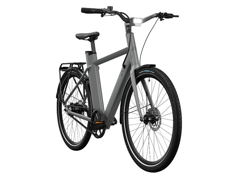Un vélo électrique gris avec transmission par courroie.