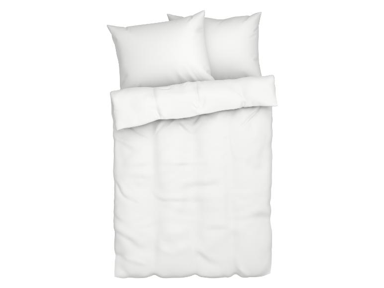 Lit avec draps et oreillers blancs.