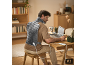 Homme travaillant à un bureau avec un gilet chauffant sur le dos et le cou.