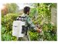 Un homme pulvérise des plantes dans le jardin avec un pulvérisateur dorsal Parkside.