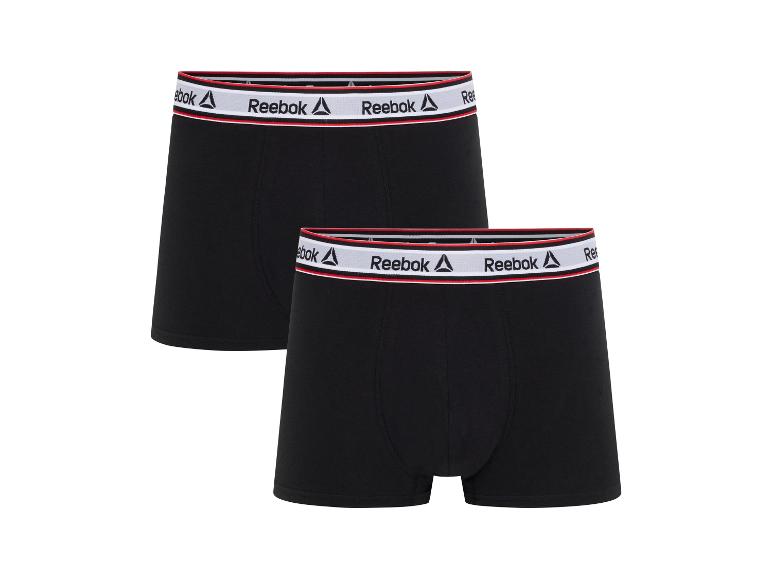 Deux boxers Reebok noirs avec une ceinture blanche et rouge.