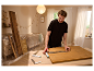Un homme utilise des équerres et un mètre Parkside pour mesurer une planche de bois.