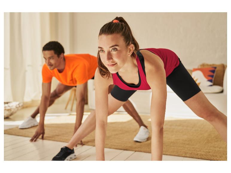Une femme et un homme font du yoga à la maison.