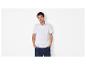Homme en polo blanc et short bleu marine, les mains dans les poches.