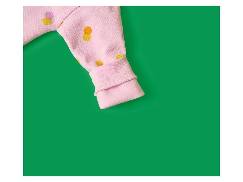 Manche rose à pois colorés sur fond vert.