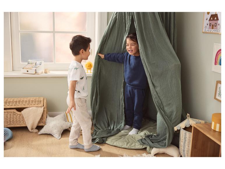 Deux garçons jouent dans une chambre d'enfant avec une tente de jeu.