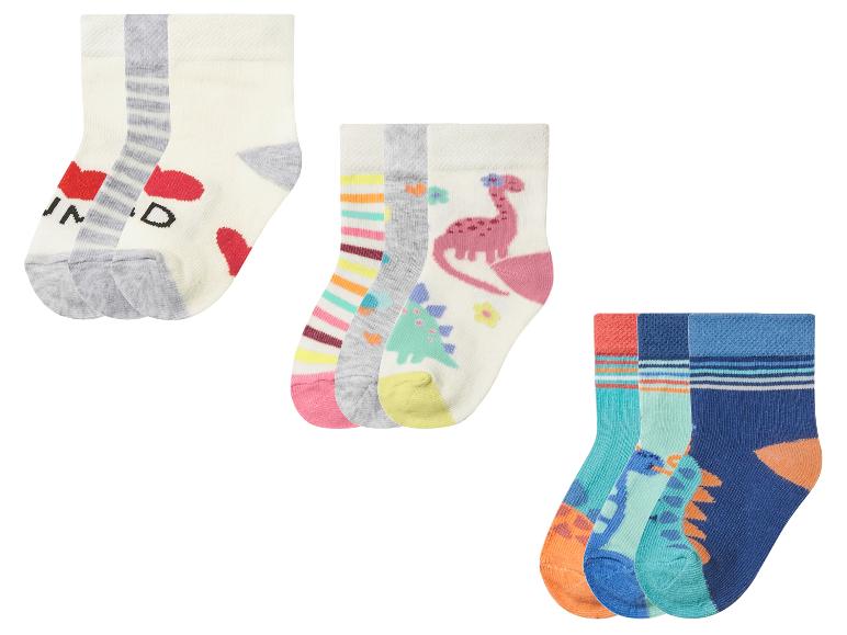 Trois ensembles de chaussettes pour enfants : un avec des cœurs, un avec des dinosaures et un avec des rayures et des dinosaures.
