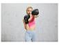 Une femme en tenue de sport s'entraîne à la boxe avec des gants de boxe noirs Crivit.