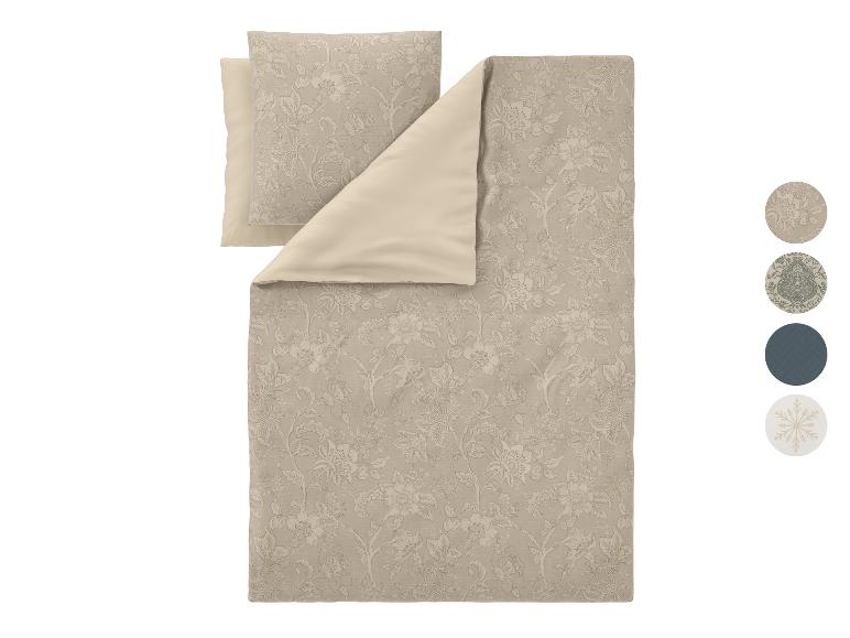 Parure de lit beige à motif floral avec une face unie.