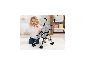 Poussette pour poupée BAYER DESIGN avec sac et un enfant qui joue.