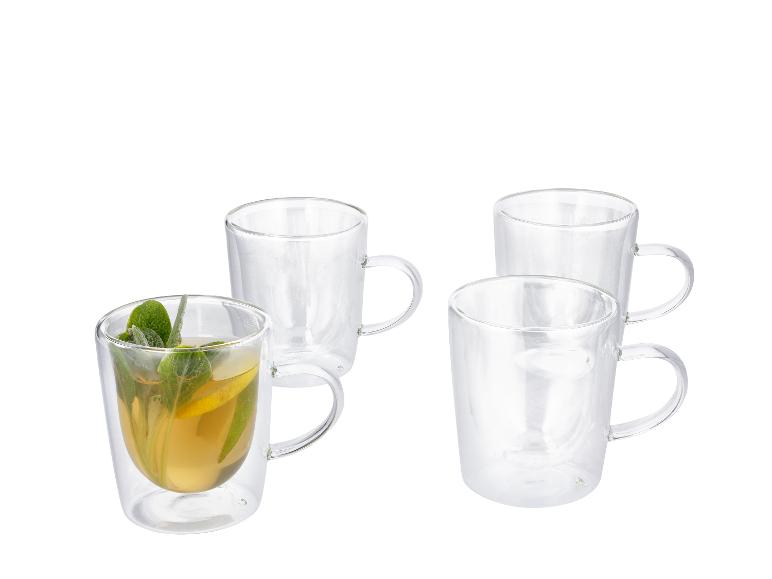 Quatre tasses en verre à double paroi, une avec du thé, du citron et de la menthe.