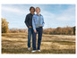 Un homme et une femme en jeans et vestes en jean posent dans un champ.