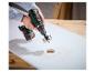 Perceuse sans fil avec scie cloche perçant une planche de bois.