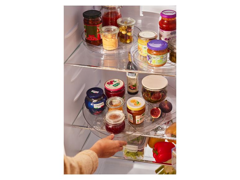 Une main retire du réfrigérateur une étagère rotative avec des pots de confiture, du miel et des produits italiens.