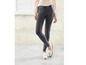 Une femme porte un legging en jean noir et des mocassins blancs.
