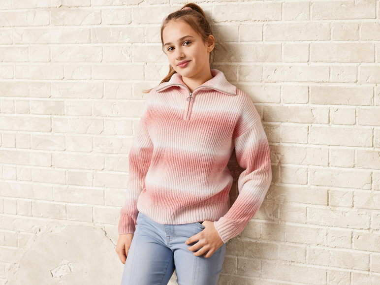 Une fille porte un pull rayé rose et un jean bleu.