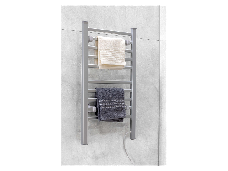 Deux serviettes pendent sur un sèche-serviettes électrique dans la salle de bain.