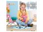 Fille jouant avec une poupée et un jeu de pêche avec des pingouins colorés.