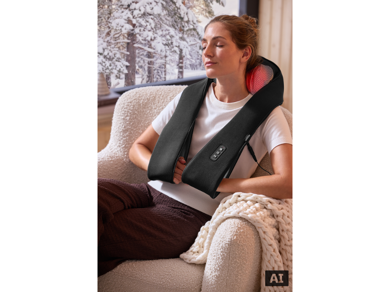 Femme se détendant avec un masseur de cou devant une fenêtre hivernale.