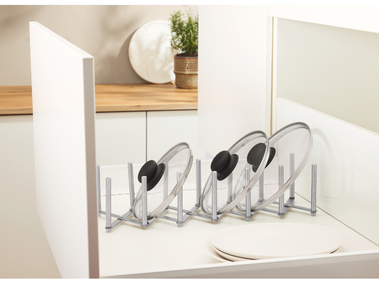 Organisateur de couvercles de casseroles dans un tiroir de cuisine, maintenant plusieurs couvercles en verre à la verticale.