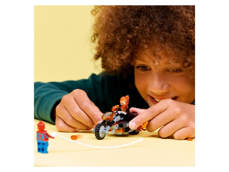 Enfant jouant avec une moto jouet et des figurines sur fond jaune.