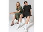 Une femme en robe verte et un homme en t-shirt noir imprimé et short.