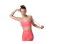 Femme en brassière de sport et legging roses, tenant une bande de résistance rose.