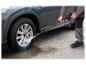 Un homme nettoie un pneu de voiture avec un nettoyeur haute pression Parkside.