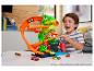 Un garçon joue avec un ensemble de jeu dinosaure Hot Wheels, comprenant une piste et plusieurs voitures.