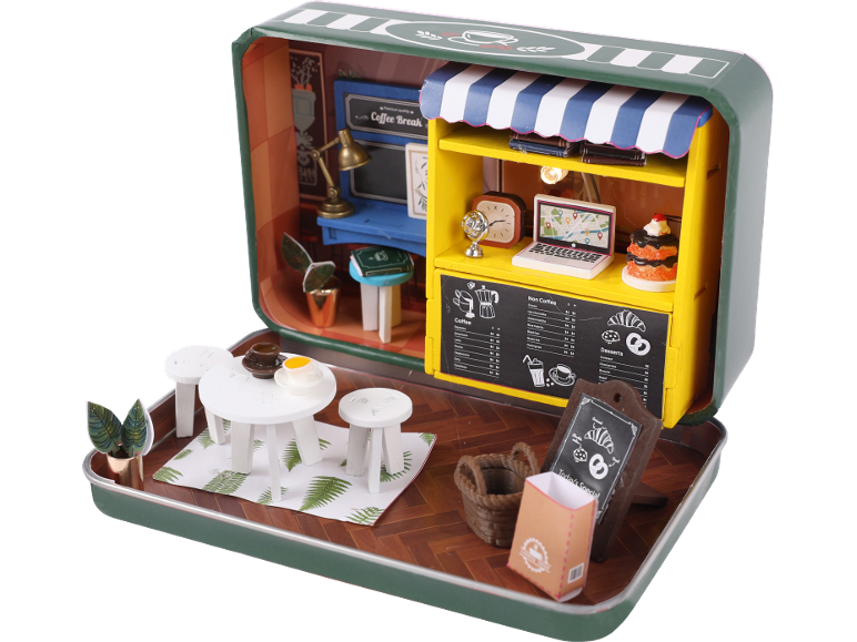 Diorama miniature de café dans une boîte en étain, avec un comptoir de café, des sièges extérieurs et un menu.