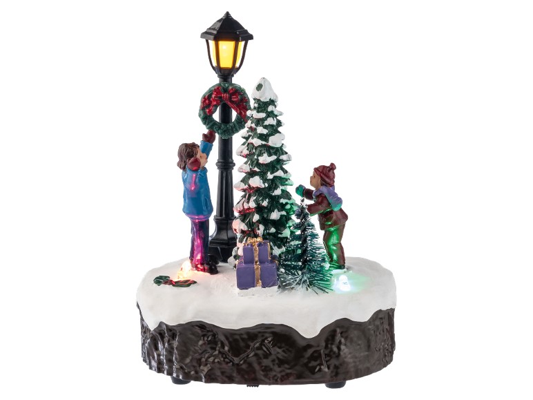 Décoration de Noël lumineuse avec des figurines d'enfants, un sapin et un réverbère.