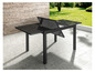 Une table de jardin noire avec un plateau en verre, pliée dans un jardin.