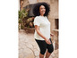 Une femme porte un t-shirt blanc et un pantalon capri noir.