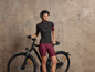 Une femme en tenue de cycliste avec un vélo.