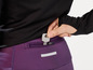 Gros plan d'une femme mettant une clé Birdy dans la poche de son legging de sport violet.