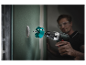 Un homme perce un trou dans un mur avec une perceuse Bosch.