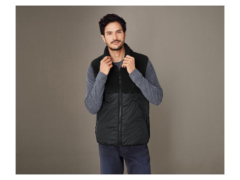 Homme portant un gilet en polaire noir avec une capuche.