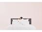 Une femme dort sous une couette et un oreiller sur un lit.