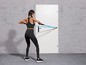 Une femme en tenue de sport fait des exercices avec un élastique de résistance.