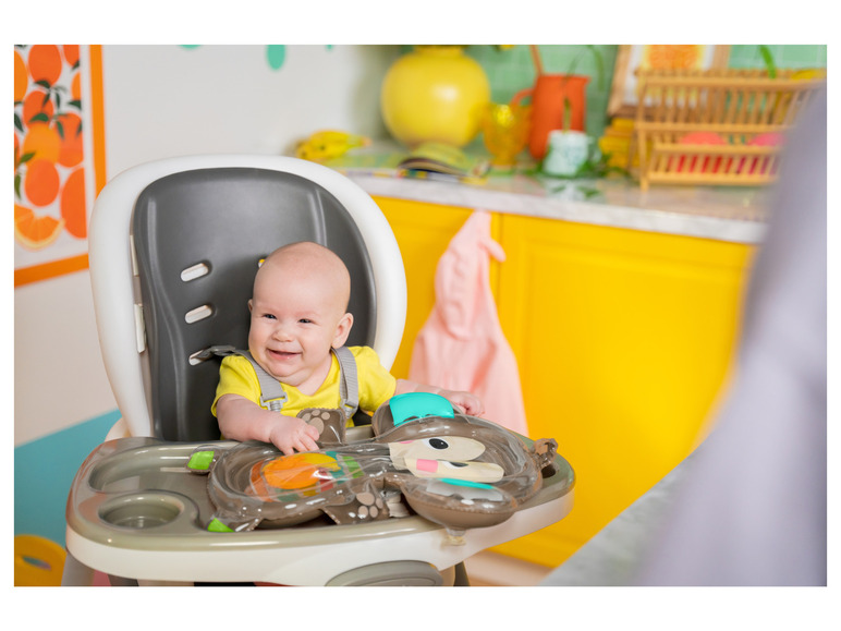 Un bébé assis dans une chaise haute avec une assiette amusante en forme d'ours.
