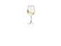 Un verre de vin blanc avec un bord doré.