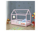 Un lit d'enfant rose en forme de maison avec un ciel de lit.