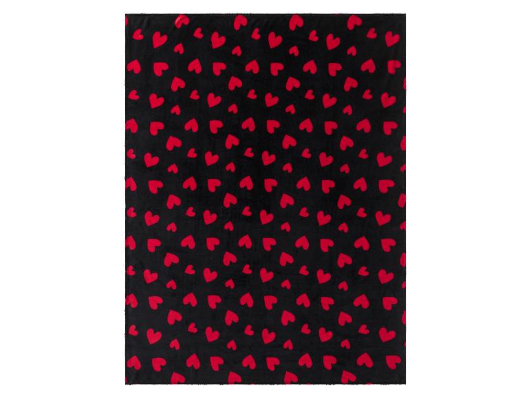 Une couverture noire avec un motif de cœurs rouges.