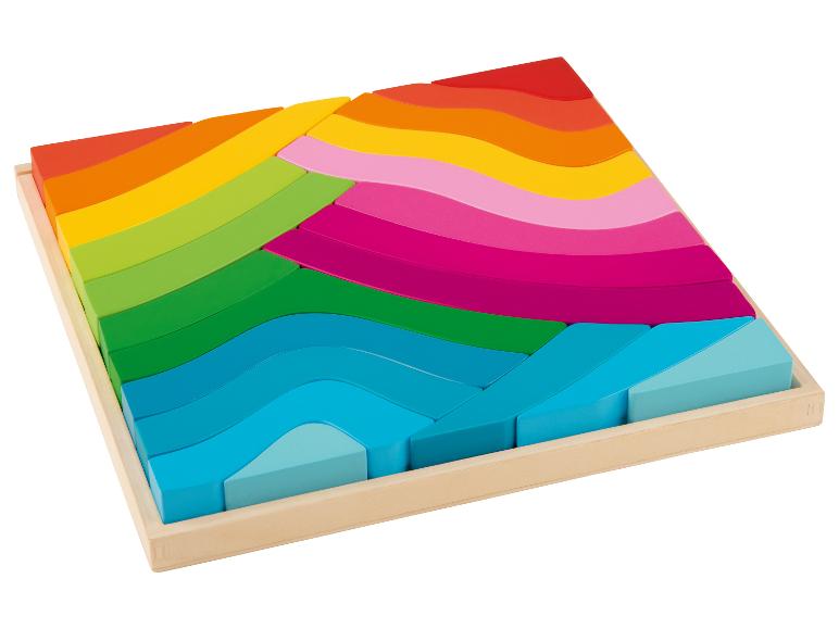 Puzzle en blocs de bois avec des couleurs arc-en-ciel dans un cadre en bois.