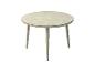 Table d'extérieur ronde avec un plateau texturé gris clair et quatre pieds coniques.
