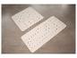 Deux tapis de bain en plastique clairs sur un carrelage gris.
