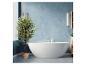 Salle de bain moderne avec baignoire îlot, plante en pot et murs bleus.