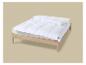 Couette blanche sur un lit en bois clair.