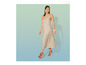 Une femme portant une robe beige et des sandales à plateforme marron.