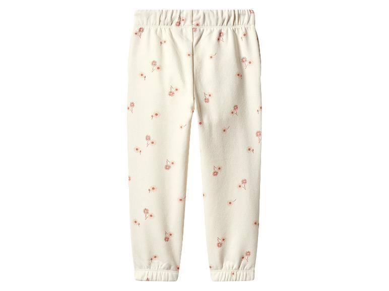 Pantalon de jogging pour enfant couleur crème avec un motif floral délicat.